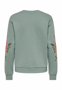 Sweat-shirt vert menthe avec broderie florale sur les manches, poignets et ourlet côtelés. Tissu doux avec une coupe décontractée et un col rond.