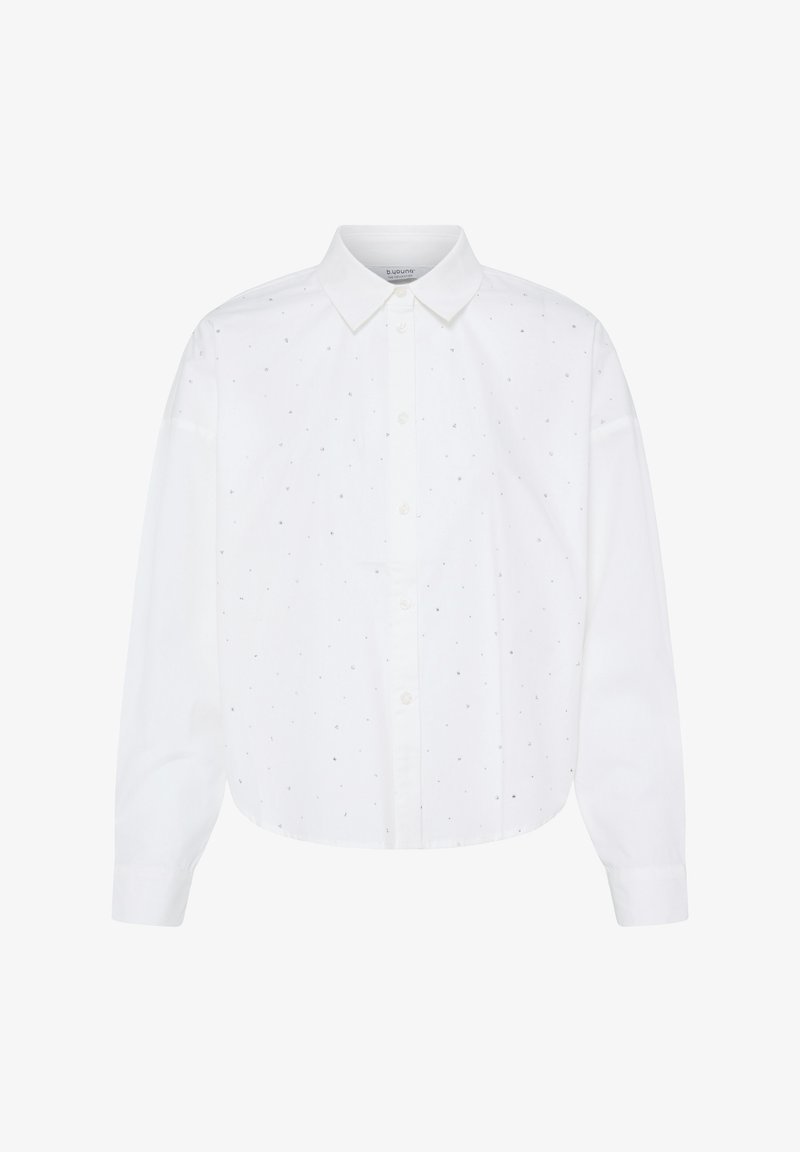 Chemise blanche à manches longues avec petits points noirs dispersés et col pointu, présentée sur fond blanc uni.