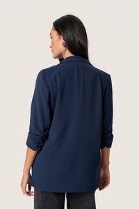 Navy blue long-sleeve shirt with a relaxed fit, buttoned cuffs, and a smooth, lightweight fabric. Features a classic collar and straight hem.