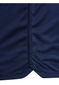 Marinblå meshtyg med en slät yta, med sömmar som är sydda och en något rundad fåll i botten. Andningsbart och lätt design.