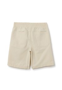Pantalones cortos beige con una cinturilla elástica, que cuentan con dos bolsillos traseros con solapas rectangulares. Tejido suave con un diseño sencillo y sin patrones.
