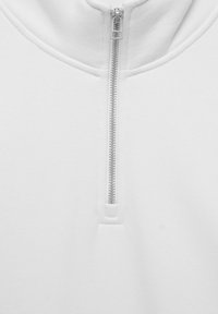 Felpa bianca con zip, caratterizzata da un colletto alto, una texture liscia e una cerniera metallica che si estende lungo la parte frontale. Design semplice senza motivi.