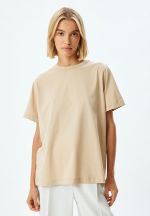 Beige katoenen t-shirt met een ronde hals, korte mouwen en een ontspannen pasvorm. Glad textuur en eenvoudig ontwerp, met minimale stikdetails.