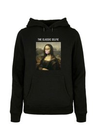 Svart huvtröja med en grafik av Mona Lisa som blåser en bubbelgumskula, texten "DEN KLASSISKA SELFIE" ovanför bilden.