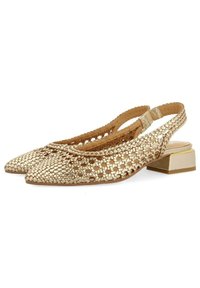 Zapatos dorados de slingback trenzados con punta afilada, tacón cuadrado bajo y patrón texturizado. Presentan una correa trasera segura y lados abiertos.
