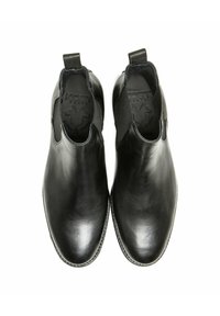 Une paire de bottes Chelsea en cuir noir à enfiler, avec des panneaux élastiques sur les côtés et des languettes de tirage, vues de dessus sur un fond blanc.