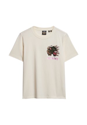 T-shirt en coton crème avec des manches courtes. Présente un graphique brodé noir et rouge d'un chat sauvage avec le texte rose "urgence" en dessous.