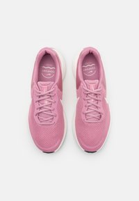 Baskets de sport rose clair avec une tige en mesh respirant, un bout arrondi, des lacets plats et une semelle rembourrée en blanc cassé. Détail de logo subtil inclus.