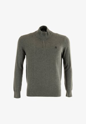 Suéter gris de punto, con un alto cuello y cierre de media cremallera. Incluye un pequeño logo en el lado izquierdo del pecho.