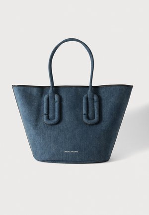 Torba tote z ciemnoniebieskiego denimu z dwoma wyściełanymi uchwytami i logo "MARC JACOBS" nadrukowanym na środku przodu na białym tle.
