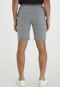Gråternede shorts lavet af letvægtsstof, med elastisk talje og sidelommer, der slutter lige over knæet.