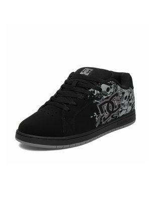 Zwarte lage skate schoen met schedel en abstract patroon, DC-logo aan de zijkant en op de tong, zwarte veters en grijze zool.