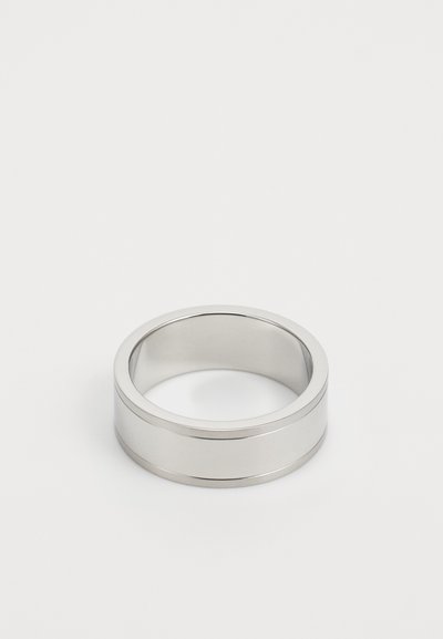 Bague en métal argenté avec une surface lisse et polie. Présente une large bande et deux rainures horizontales pour le détail.