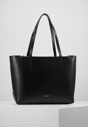 Czarna skórzana torba typu tote z podwójnymi paskami na ramię, prostokątnym kształtem i małym złotym logo "Ted Baker" z przodu, na jednolitym tle.