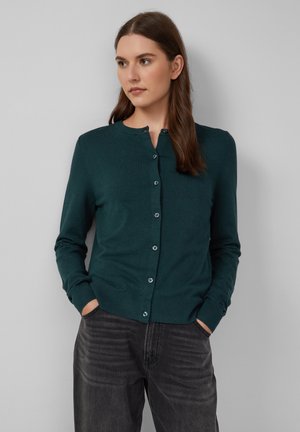 Cardigan teal avec un col rond, des manches longues et une fermeture à boutons à l'avant. Il possède un ourlet et des poignets côtelés, fabriqué à partir d'un matériau doux et texturé.