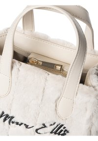 Witte handtas van nep bont met leren handvatten en een gouden rits. Heeft zwarte geborduurde tekst. Zachte textuur met een gewatteerd ontwerp.