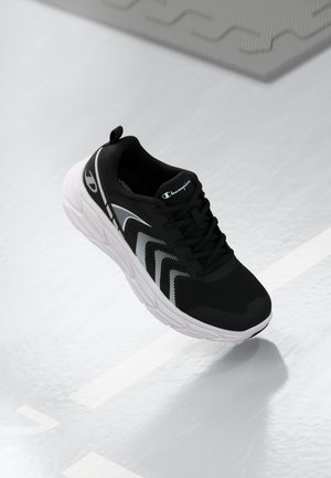 Black athletic shoe with a mesh upper, white sole, and subtle striped patterns on the side. Features a cushioned collar and laces.