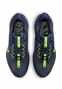 Scarpe sportive blu navy con accenti verdi, in materiale mesh e superficie testurizzata. Presentano un sistema di allacciatura con un toggle e un logo.