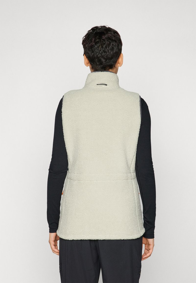 Hellgraue Fleeceweste mit hohem Kragen, strukturiertem Oberflächenmaterial und seitlichen Taschen. Schwarzes Langarmshirt darunter mit minimalistischem Design.