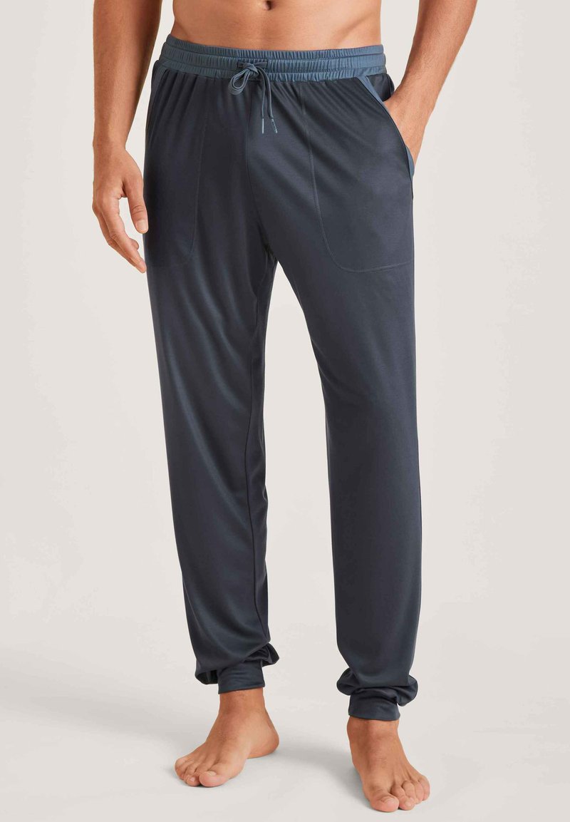 Marinblauwe sportbroek met een trekkoord in de taille, elastische manchetten en zijzakken. Gemaakt van glad, lichtgewicht materiaal.