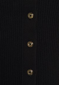 Black ribbed cardigan featuring five gold-tone buttons along the placket, emphasizing a textured and structured design.