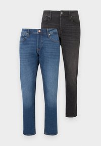 Δύο ζευγάρια τζιν: ένα σκούρο μπλε με ξεθωριασμένο φινίρισμα και πορτοκαλί ραφές, και ένα μαύρο μονόχρωμο με στενή εφαρμογή και κανονικές τσέπες.