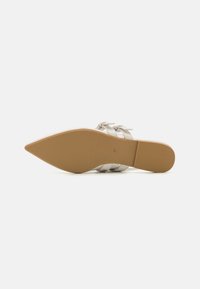 Chaussure à talon transparent à bout pointu avec une semelle en caoutchouc beige. Présente plusieurs fines brides et une finition blanche brillante. Taille 37 indiquée.