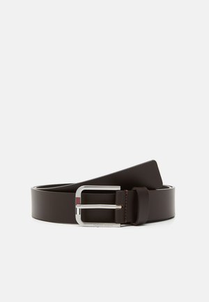 Cinturón de cuero marrón con una hebilla rectangular de plata. La hebilla presenta tres rayas horizontales en rojo, blanco y azul.