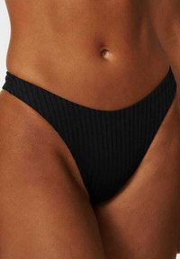 Zwarte geribbelde bikini onderkant met een low-rise ontwerp en dunne zijkanten, met een gladde textuur en een minimale bedekking.