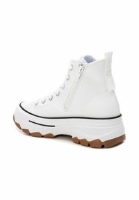 Sneaker alta bianca in tela con suola in gomma, dettaglio con zip laterale e accenti neri. Presenta una suola testurizzata per una migliore aderenza.