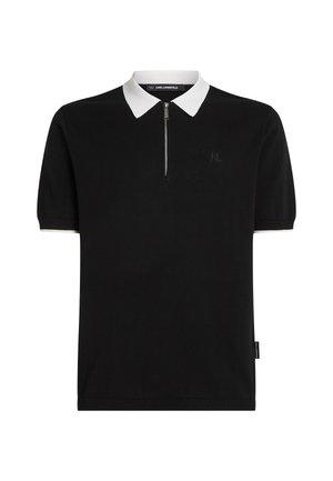 Juodas trumpas rankovėmis polo marškinėliai su balta apykakle, pusiau užtraukiama priekyje, ir išsiuvinėtu logotipu ant krūtinės. Pagaminti iš lygaus audinio.