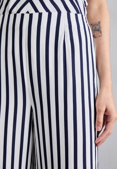 Striped wide-leg trousers with navy and white vertical stripes, featuring pleats, soft cotton fabric, and a tailored fit around the waist.