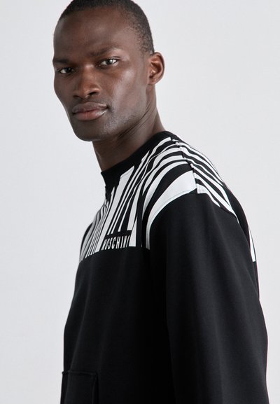 Sweatshirt preto com design de riscas brancas e logo, apresentando um colarinho alto e bolso canguru. Tecido suave e texturizado.