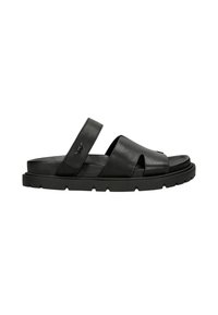 Sandale en cuir noir avec des brides croisées et une semelle en caoutchouc plate avec des détails striés, offrant un design moderne et minimaliste.