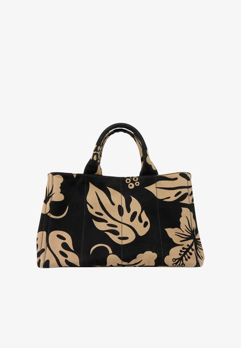 Sac fourre-tout en tissu noir avec de grands motifs de feuilles tropicales et de fleurs beiges et des poignées courtes.