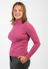 Top aderente a maniche lunghe con colletto alto in morbidissimo cotone rosa vivo, caratterizzato da una texture liscia e cuciture minime per un aspetto pulito.