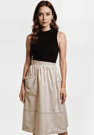 Top negro sin mangas combinado con una falda crema hasta la rodilla que presenta grandes bolsillos laterales y detalles de costura horizontal.