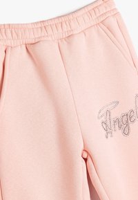 Roze katoenen sweatpants met een elastische tailleband en zijzakken. Voorzien van een glinsterend "Angel"-tekstontwerp op de linker bovenbeen.