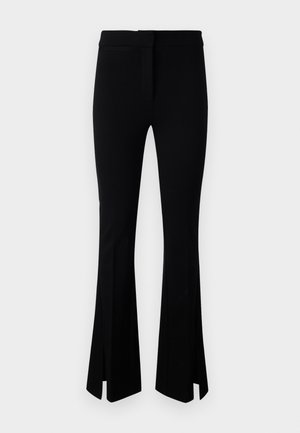 Black leggings made from stretchy fabric, featuring a flared design with side slits at the hem and a flat waistband.