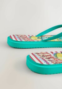 Flip-flop šlepetės su turkio spalvos padu ir dirželiais, ant pado spalvotas raštas su raudonomis, geltonomis ir mėlynomis detalėmis.