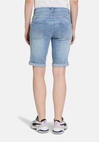 Lichtblauwe denimshorts met opgerolde manchetten, voorzien van twee zakken met gebogen stiksel en hartvormige accenten aan de achterkant.