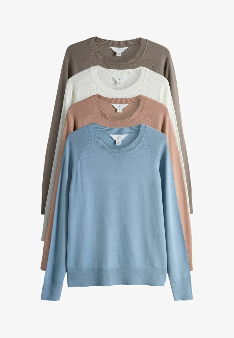 Cuatro suéteres de cuello redondo plegados en azul, beige, blanco de trenzado y marrón, apilados con etiquetas visibles en el cuello que dicen "The Set" y tamaño mediano.