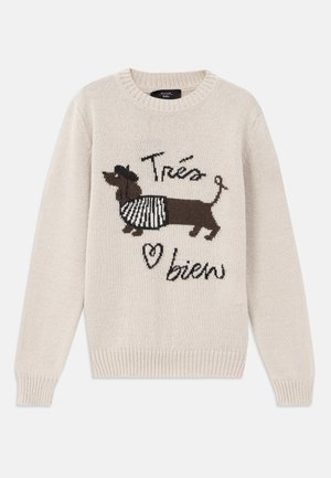 Beige knitted sweater featuring a dachshund design with a striped scarf. Text reads "Très bien" in a playful font. Ribbed cuffs and hem.