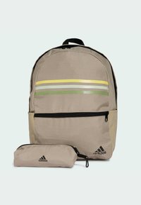 Zaino beige con zip nera, strisce verdi, gialle e grigie sul davanti; include una sacca staccabile coordinata. Realizzato in tessuto resistente.