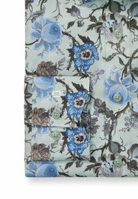 Blumenhemd aus hellgrünem Stoff mit blauen und braunen Blumen. Mit Knöpfen an den cuffs und grünen Knöpfen. Weiche Textur.