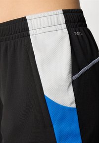 Calções de desporto pretos com um painel cinza texturizado e um detalhe azul. A cintura é elastizada para maior conforto. Inclui bolsos laterais.