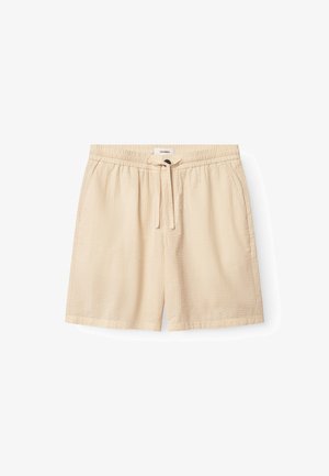 Beige shorts av texturerat tyg, med elastisk midja med dragsko, sidofickor och en ledig passform.
