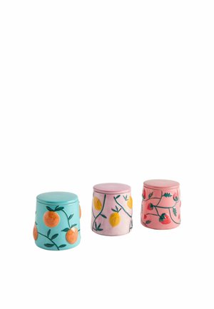 Drei keramische Gartenhocker mit Fruchtmustern: blau mit Orangen, rosa mit Zitronen und rosa mit Erdbeeren auf weißem Hintergrund.