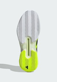Semelle de chaussure avec un design en caoutchouc blanc et vert néon, présentant un motif en chevrons et un élément de coussin d'air visible au centre.