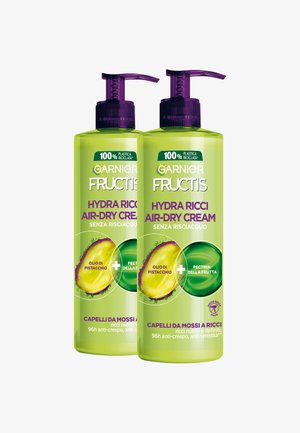 Due bottiglie di Garnier Fructis Hydra Ricci Crema a Asciugatura Naturale con erogatori viola, contenenti olio di pistacchio e pectina di frutta, per la cura dei capelli ricci.